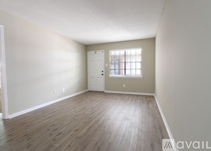 Empty room with wooden flooring and a window.