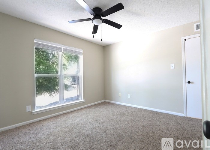 A room with a ceiling fan and a window.