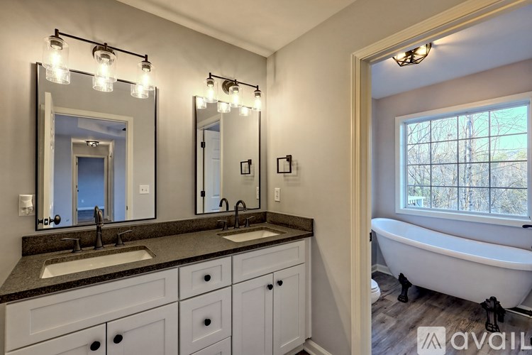 A bathroom with a tub, sink, and mirror.