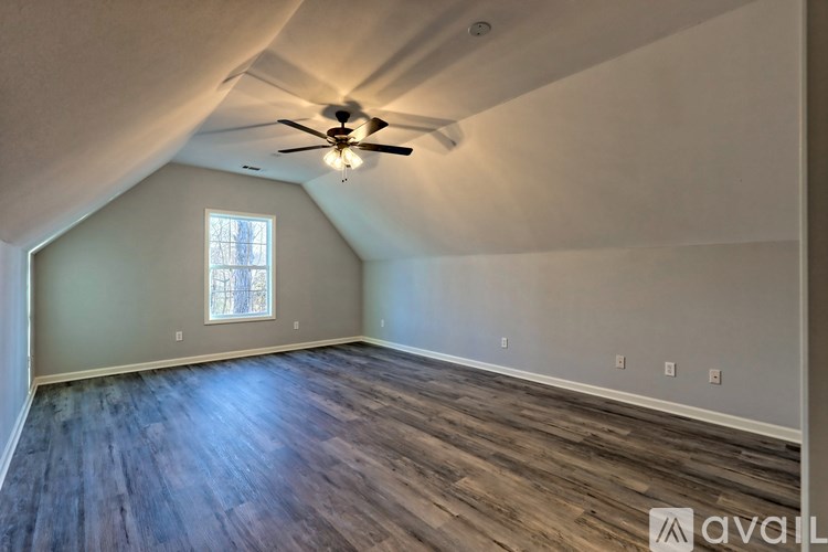 A room with a ceiling fan and a window.