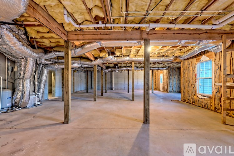A room under construction with wooden beams and insulation on the ceiling.