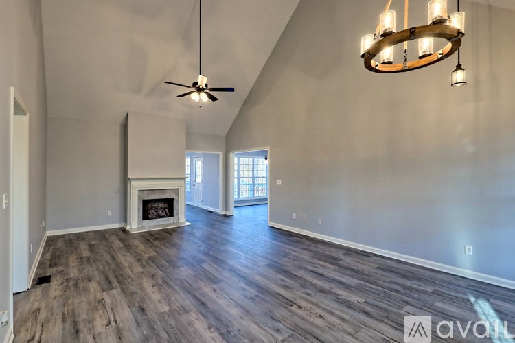 A spacious room with a fireplace and a ceiling fan.