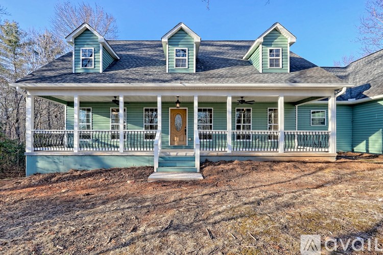 A blue house with a porch and a brown door.