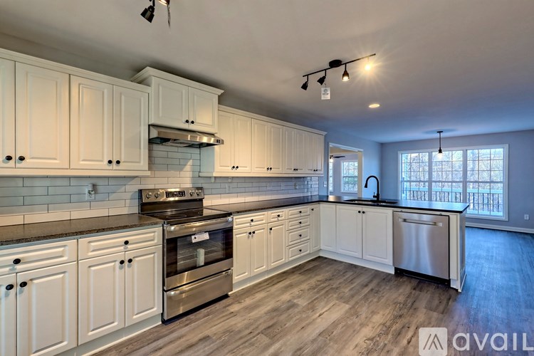 A kitchen with white cabinets and a stainless steel dishwasher.