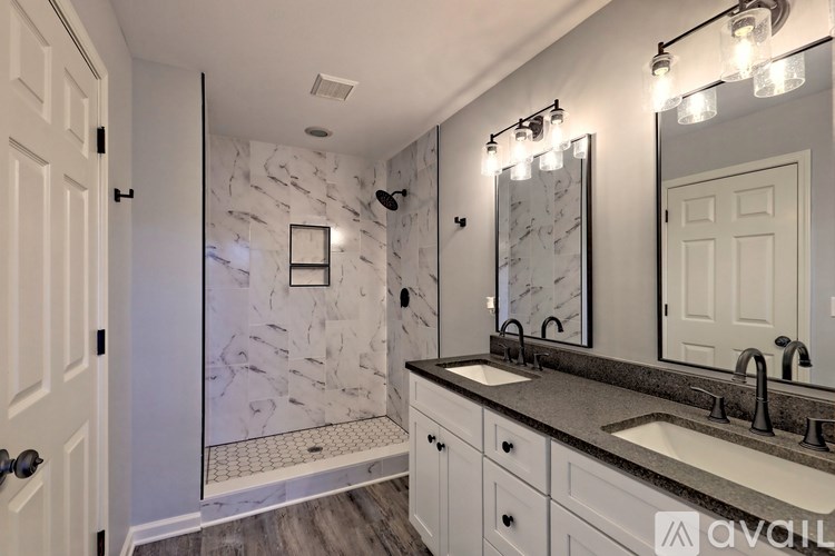A bathroom with a marble wallpaper and a walk-in shower.