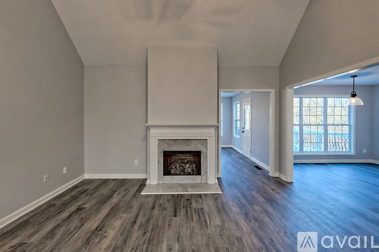 A spacious living room with a fireplace and hardwood floors.