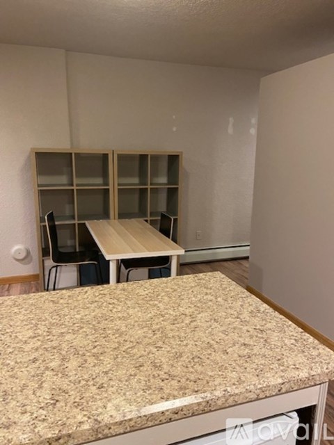 A kitchen with a granite countertop and a table with chairs.