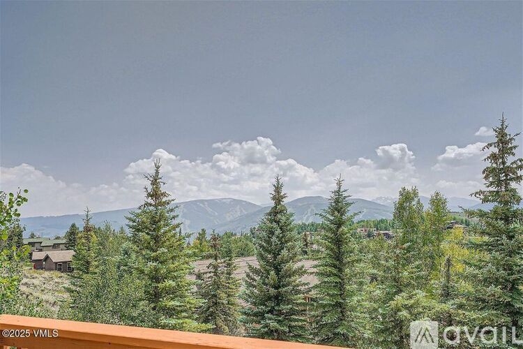 A mountain range is visible in the distance behind a forest of trees.