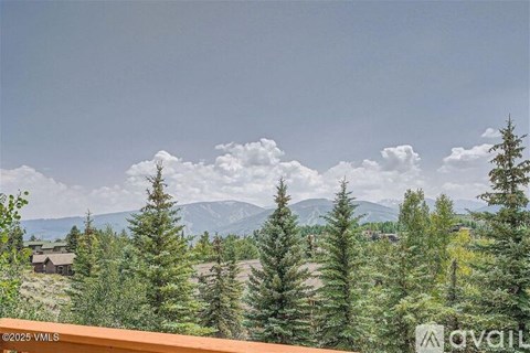 A mountain range is visible in the distance behind a forest of trees.