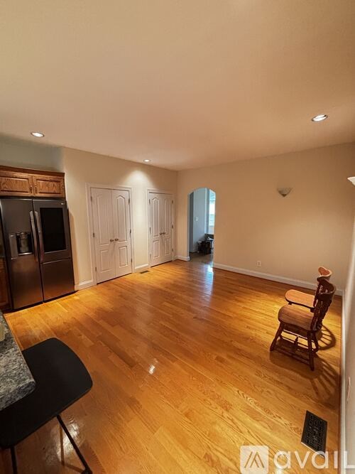 A kitchen with a wooden floor and a black chair.