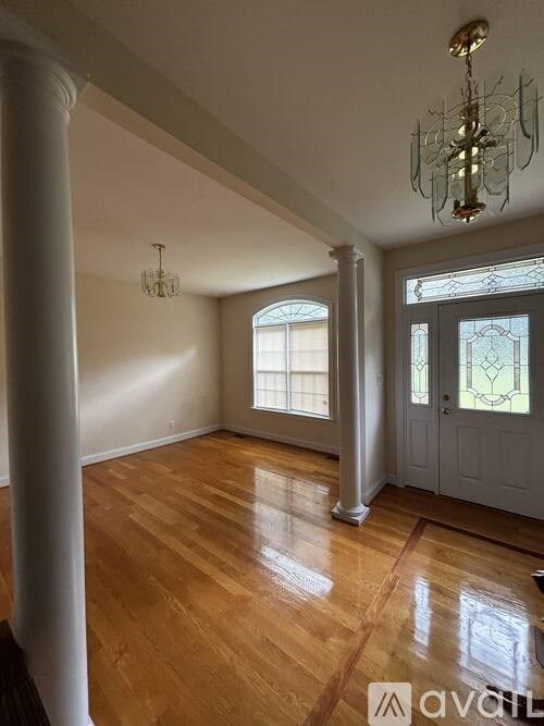 A room with wooden floors and a chandelier.