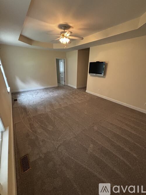 A living room with a flat screen TV mounted on the wall.
