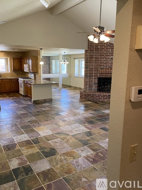 A kitchen with a tile floor and a brick fireplace.