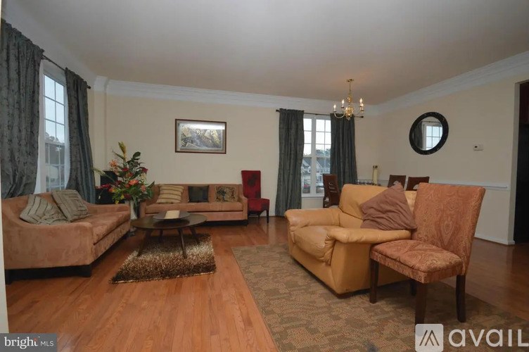 A living room with a sofa set and a chandelier.
