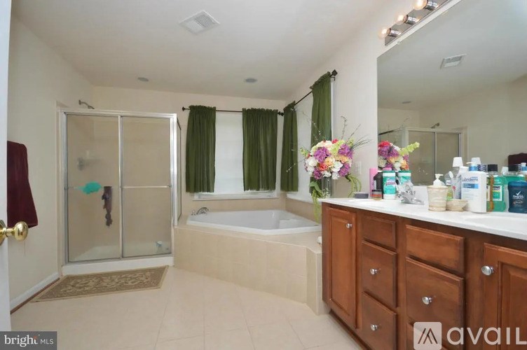 A bathroom with a tub, sink, and shower.