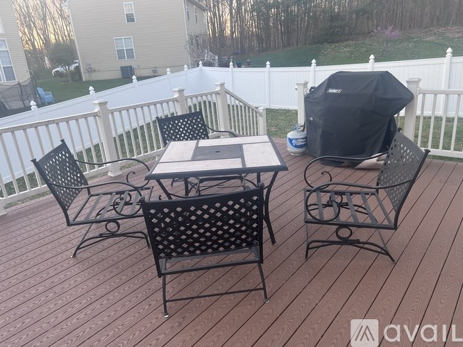 A patio with a table and chairs and a grill.