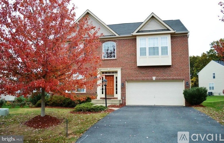 A house with a red tree in front.
