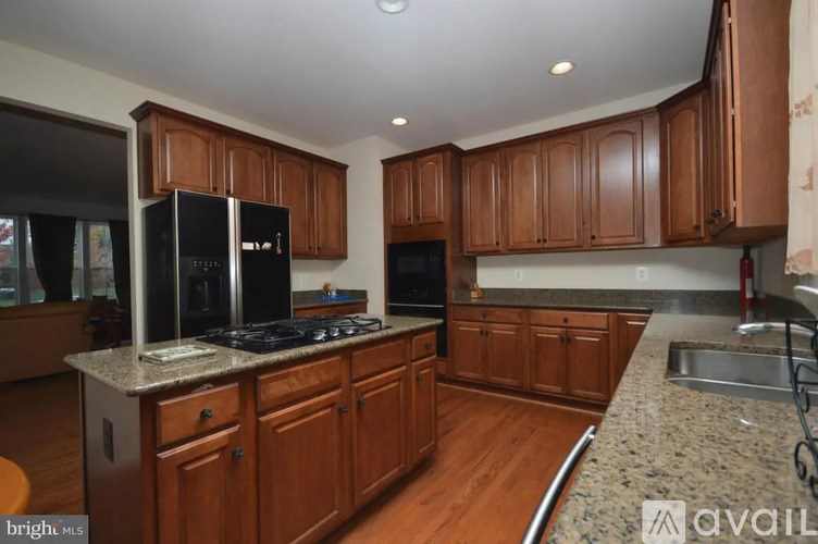 A kitchen with wooden cabinets and a granite countertop.