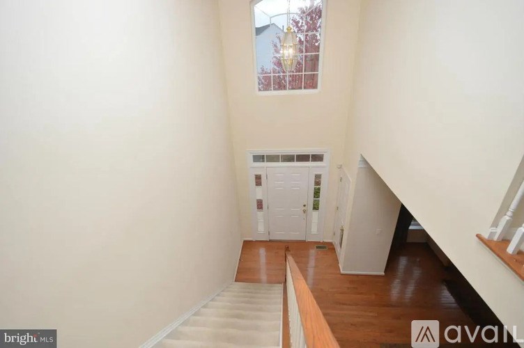 A bright white room with a window and a staircase.