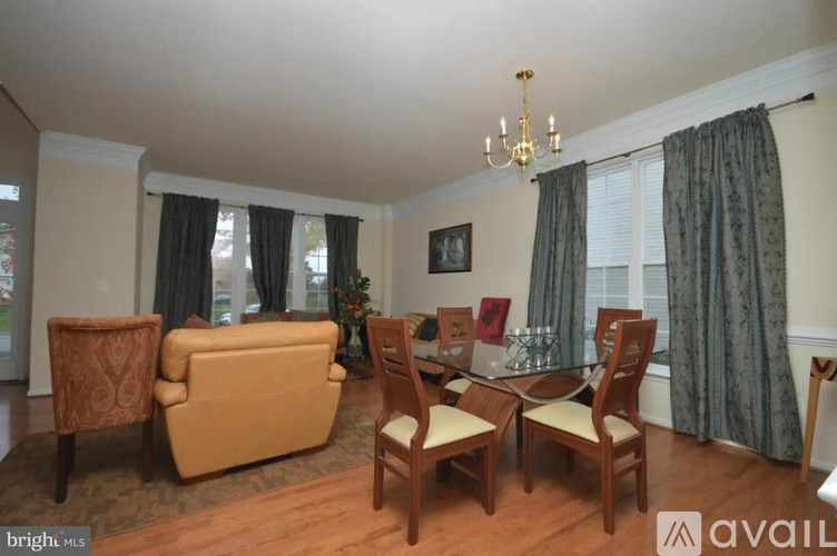 A living room with a sofa, chairs, and a dining table.