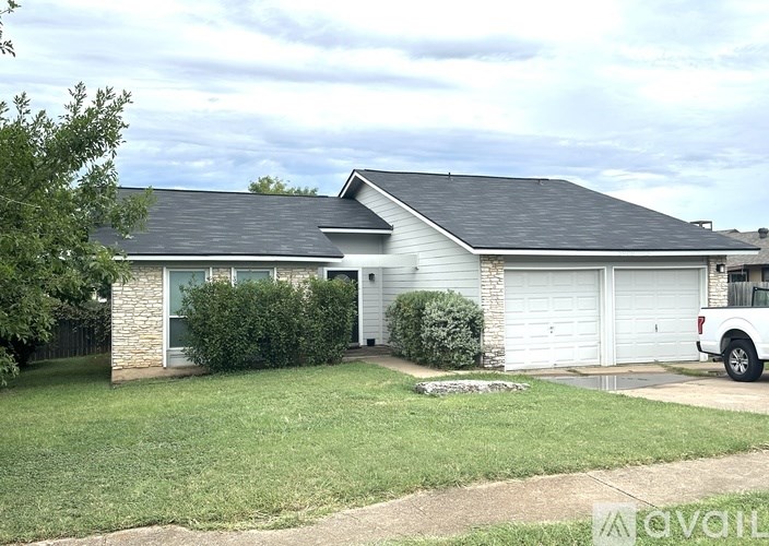 A house with a white garage door and a white car parked in front.