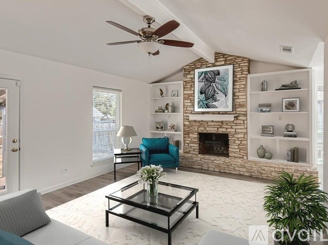 A living room with a fireplace and a blue chair.