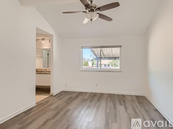 A room with a ceiling fan and a window.