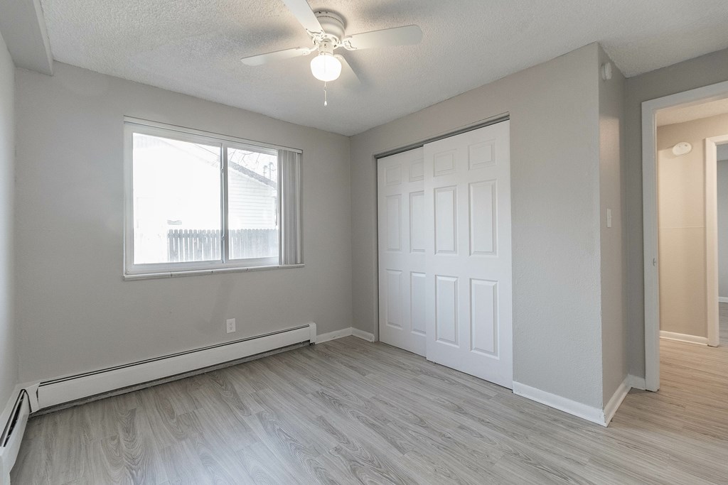 A room with a white door and a window with blinds.