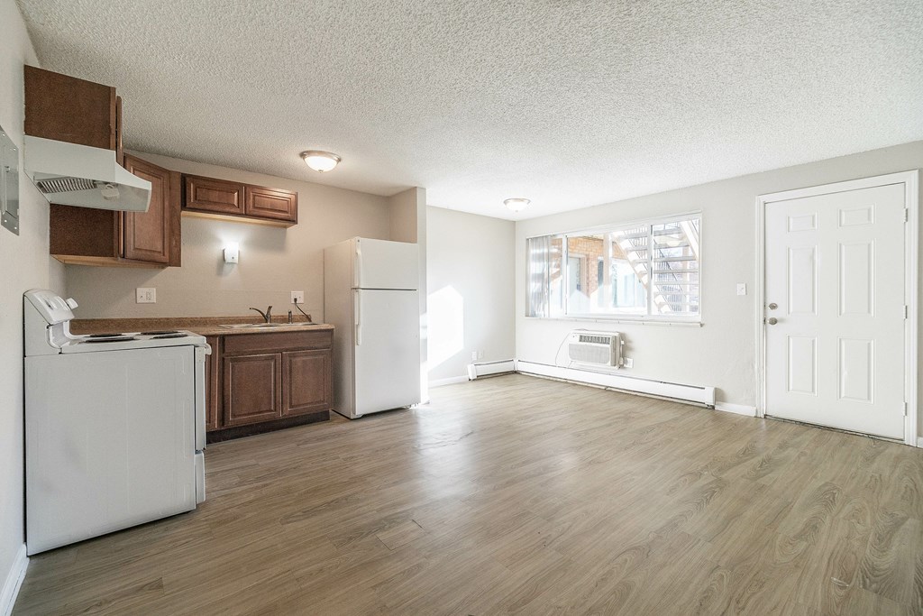 A kitchen with white appliances and wooden cabinets.