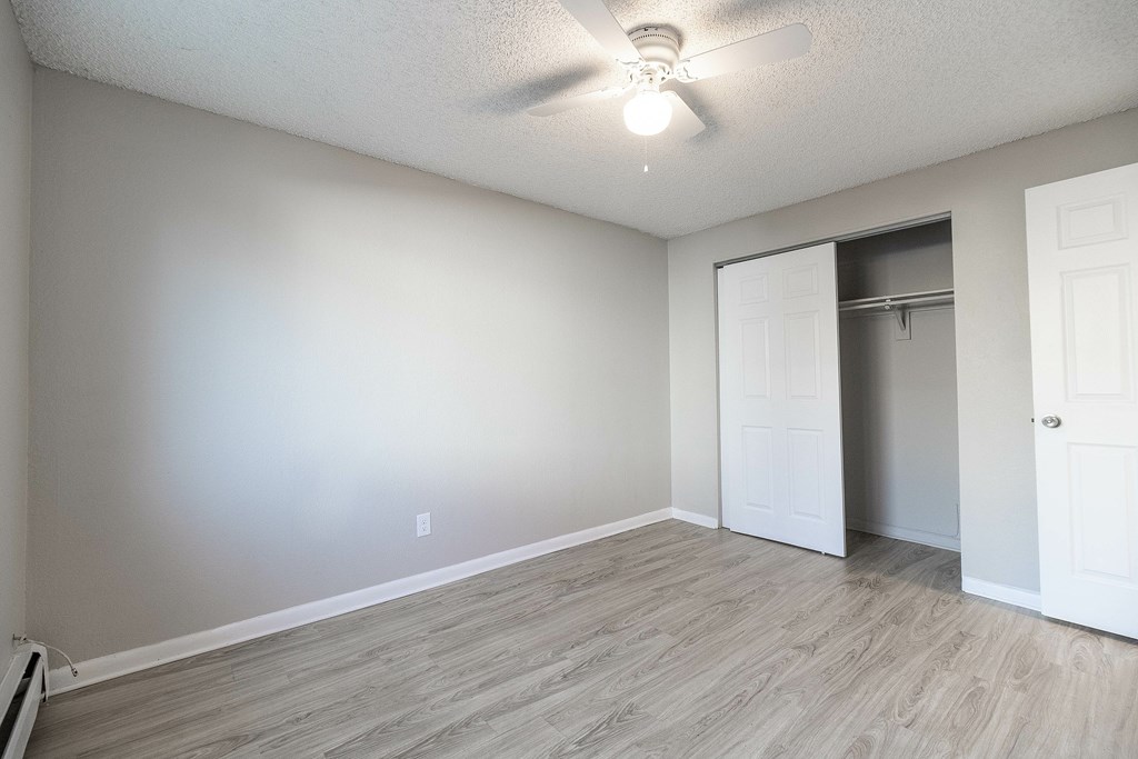 A room with a ceiling fan and a door.