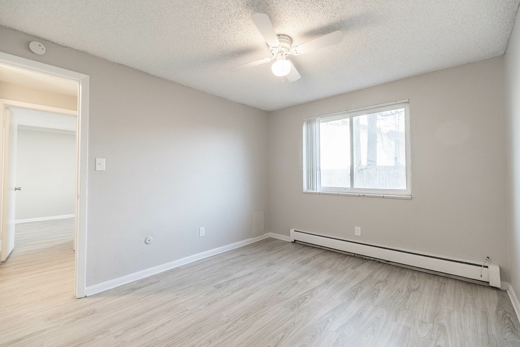A room with a window and a ceiling fan.