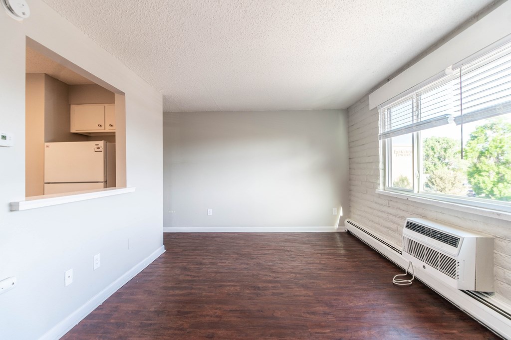 A room with a window and a wall-mounted air conditioner.