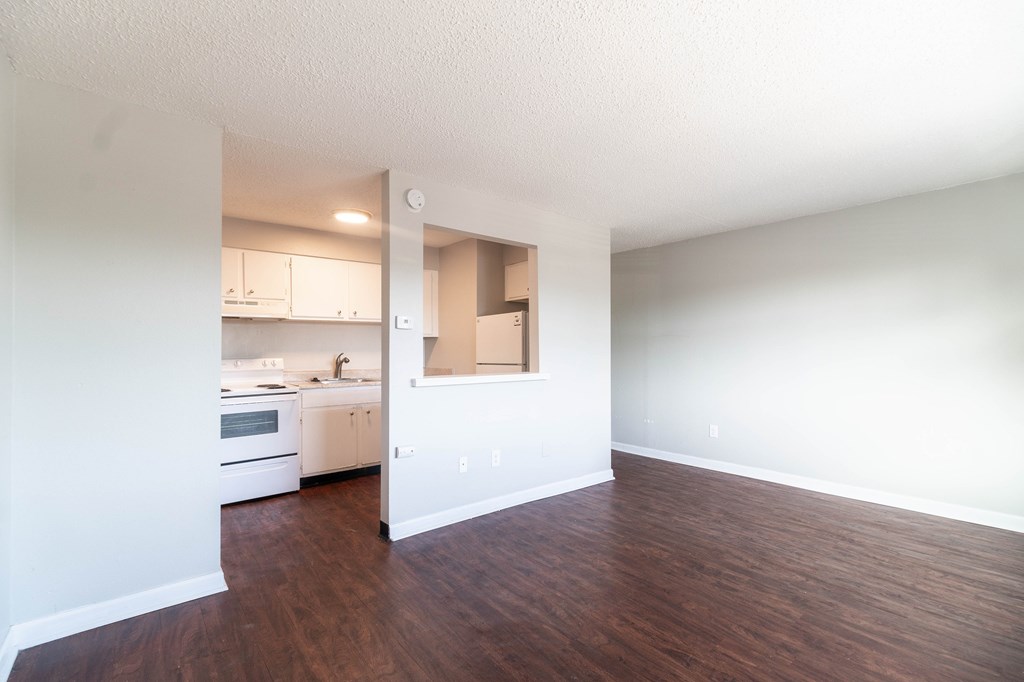 A kitchen with white cabinets and a wooden floor.