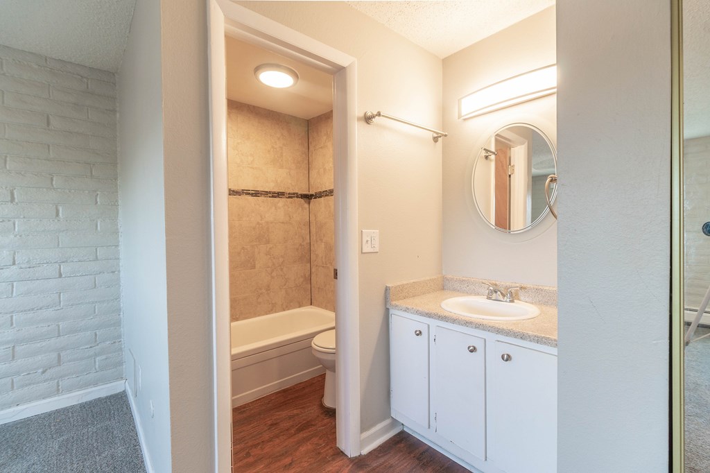 A bathroom with a white sink and a white toilet.