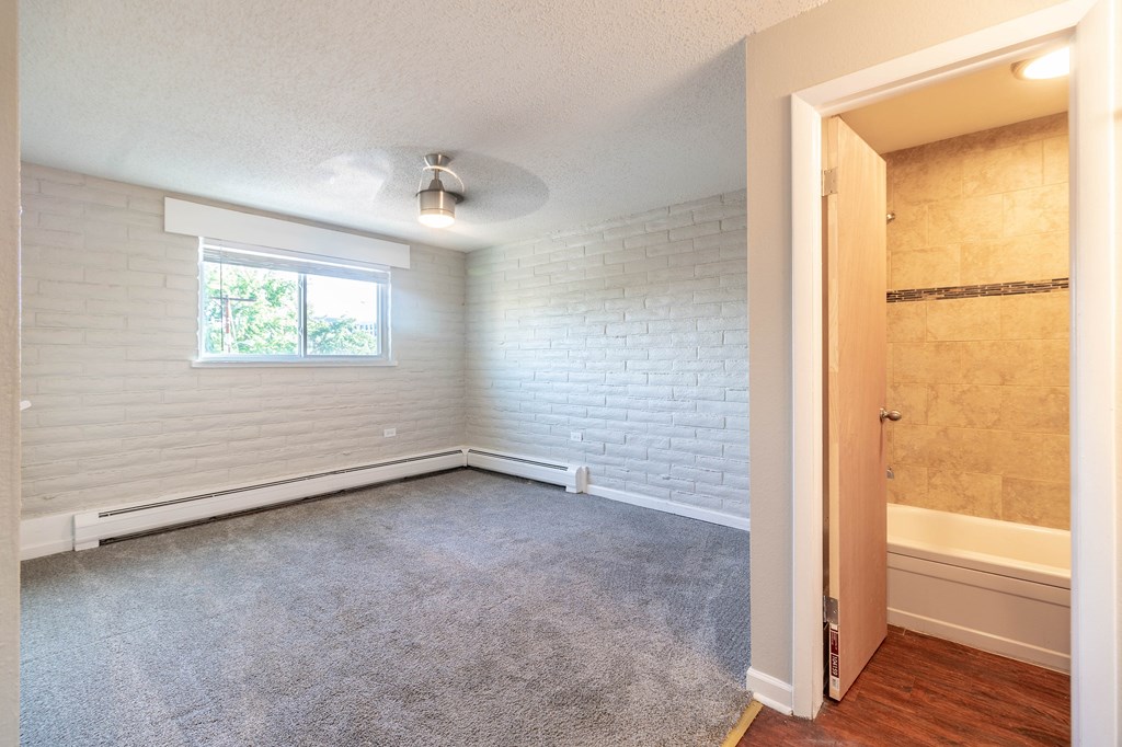 A room with a window covered by blinds and a ceiling fan.