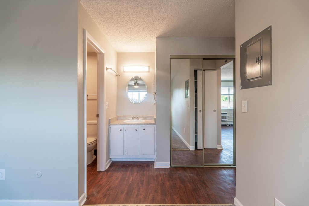 A bathroom with a sink, toilet, and mirror.