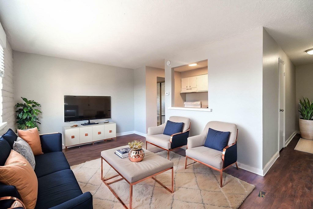 A living room with a black sofa, a coffee table, and two chairs.