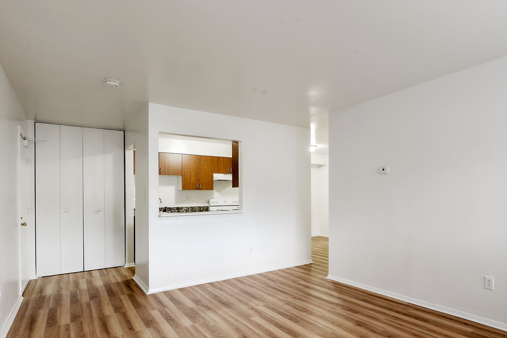 A room with a white wall and a wooden floor.
