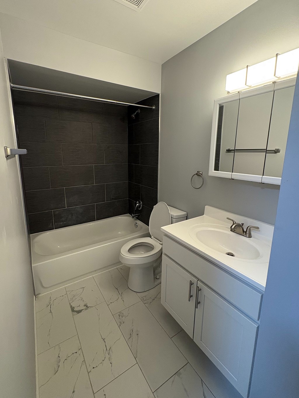 A white bathroom with a toilet, sink, and tub.