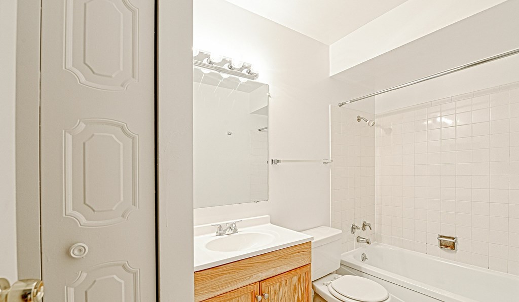 A white bathroom with a toilet, sink, and tub.
