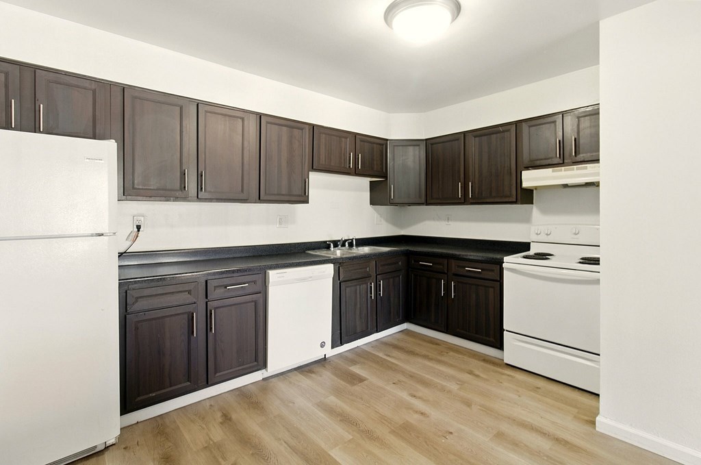 A white room with a wooden floor and a white door.