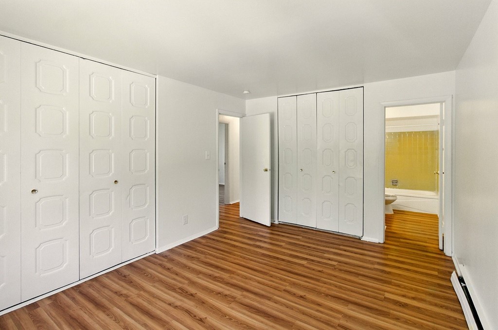 A room with a window and a wooden floor.