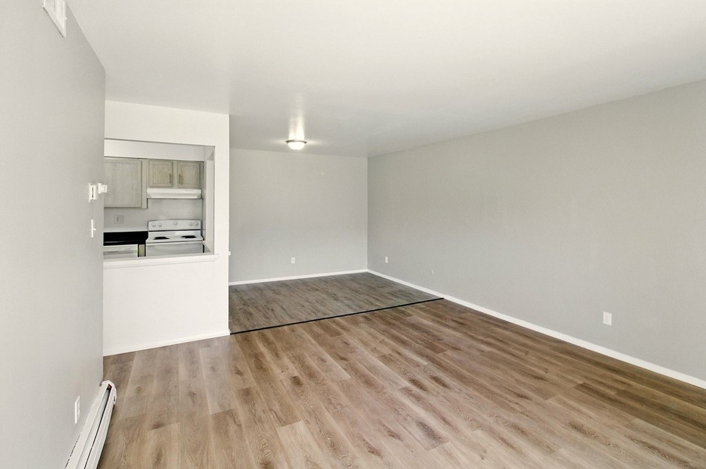 A room with wooden flooring and a white wall.