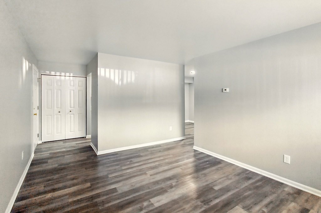 A room with wooden flooring and a white door.