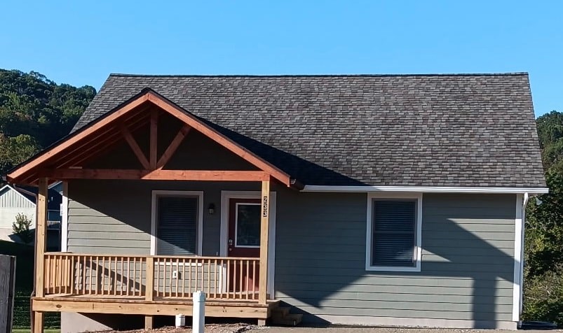 A house with a grey siding and a brown roof.