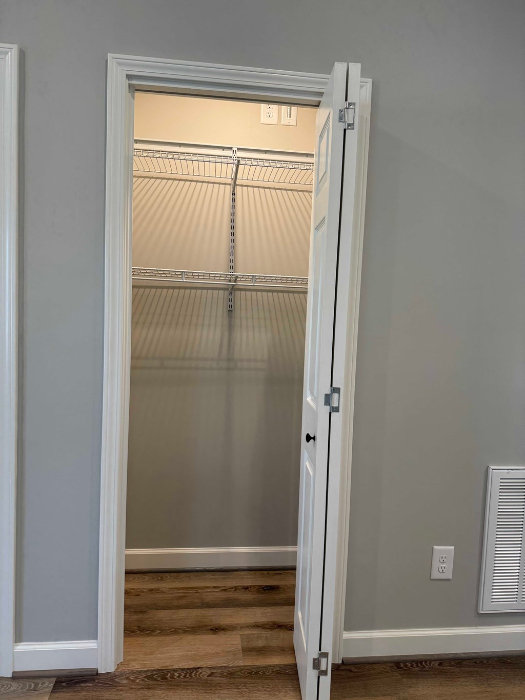 A white door is open to a room with a closet.