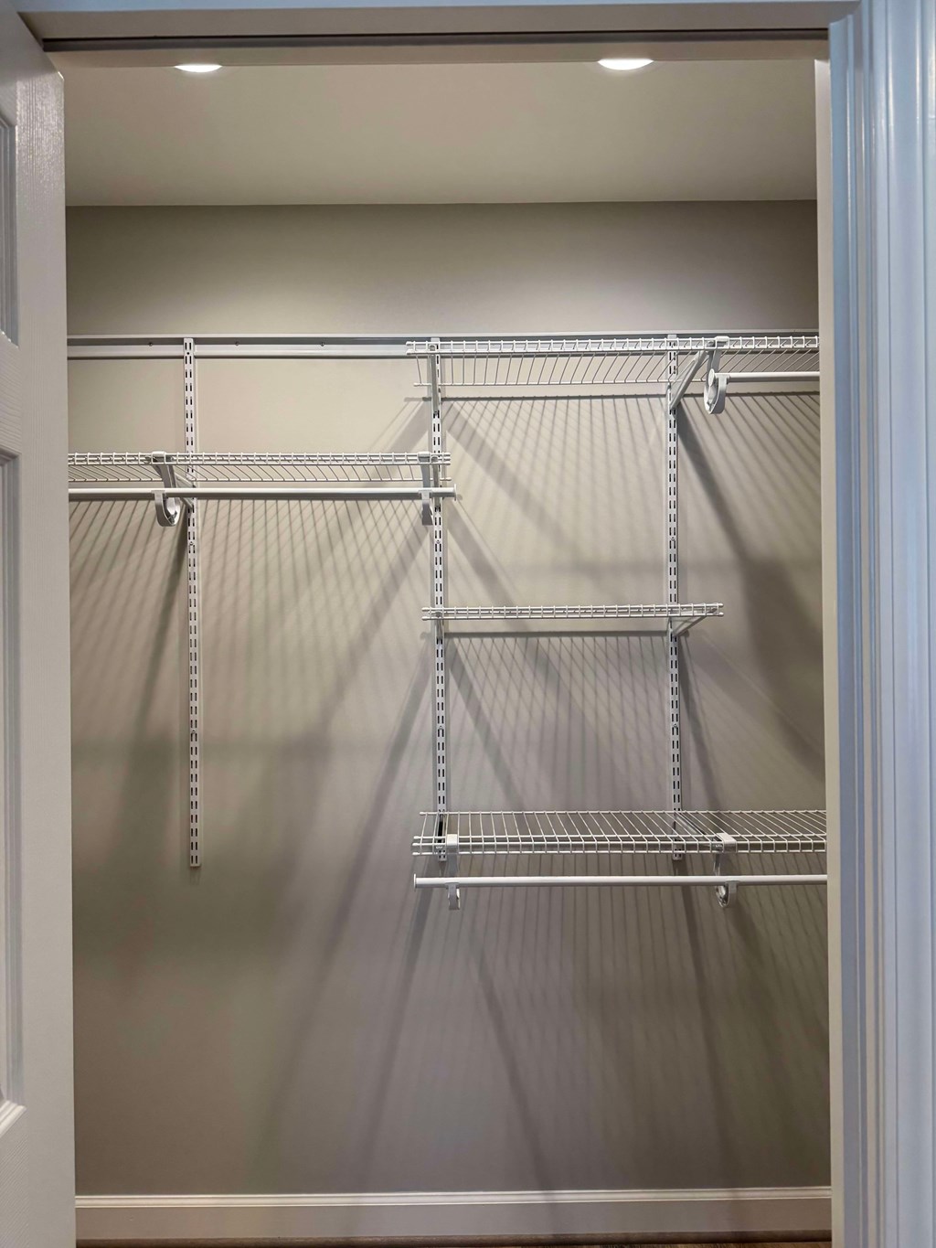 A white closet with a metal shelving unit.