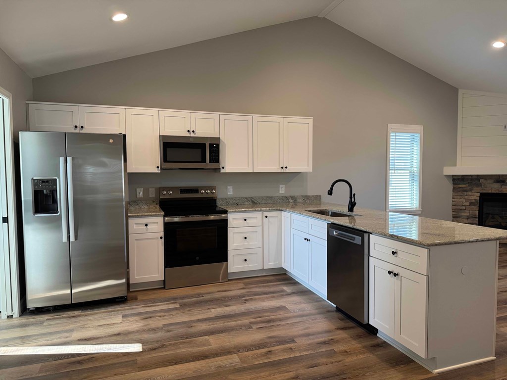 A kitchen with white cabinets and a stainless steel refrigerator.