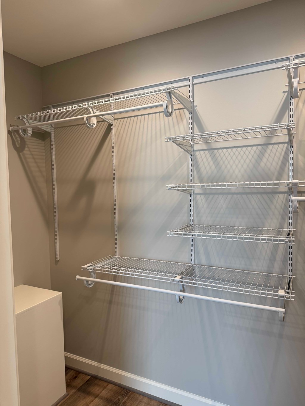 A wall-mounted metal shelving unit with four shelves.