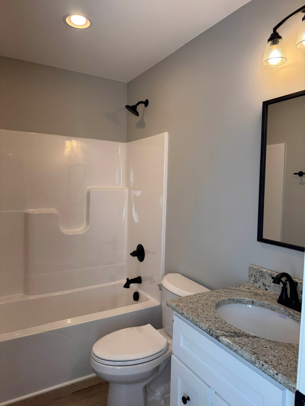 A white toilet sits next to a bathtub in a bathroom.